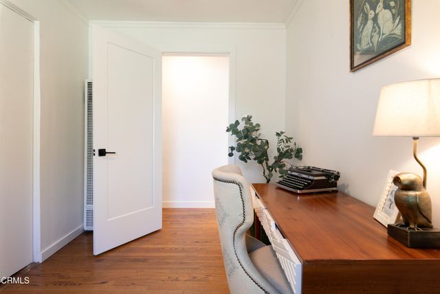 a view of a workspace with furniture and wooden floor