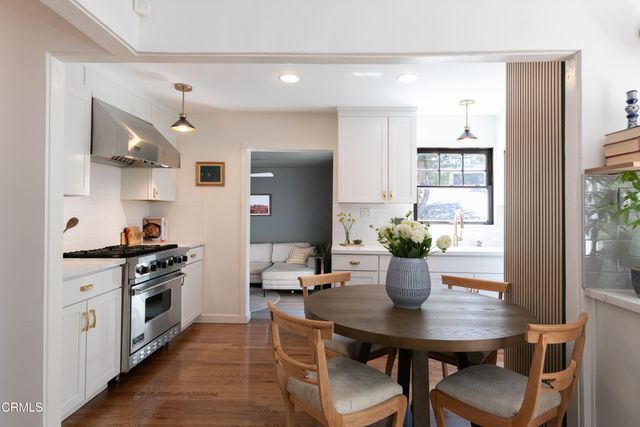 a kitchen with a table chairs stove and cabinets