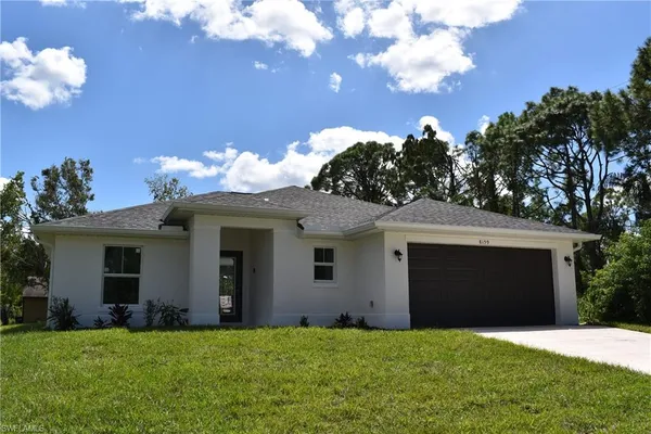 a front view of a house with a yard and garage