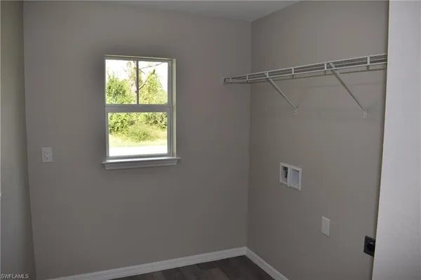 a view of a small space with wooden floor and a window