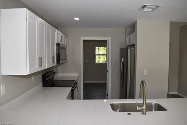 a kitchen with stainless steel appliances a sink and a refrigerator