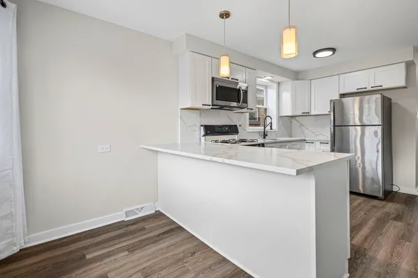a kitchen with kitchen island a sink appliances and cabinets