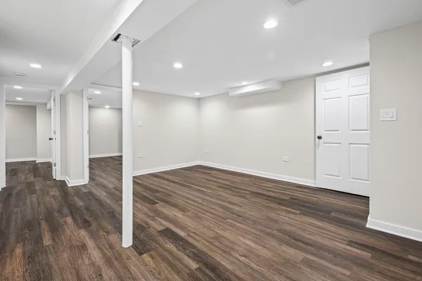 a view of empty room with wooden floor