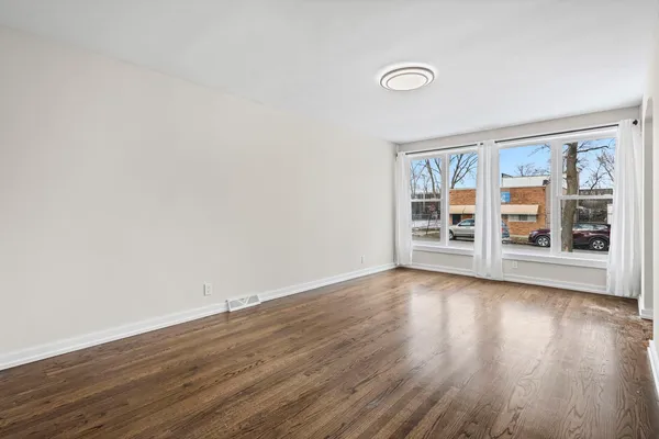 a view of a livingroom with wooden floor and window