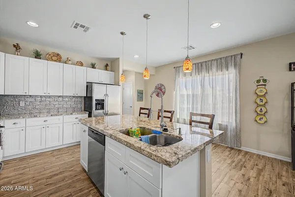 a kitchen with stainless steel appliances granite countertop a sink refrigerator and cabinets