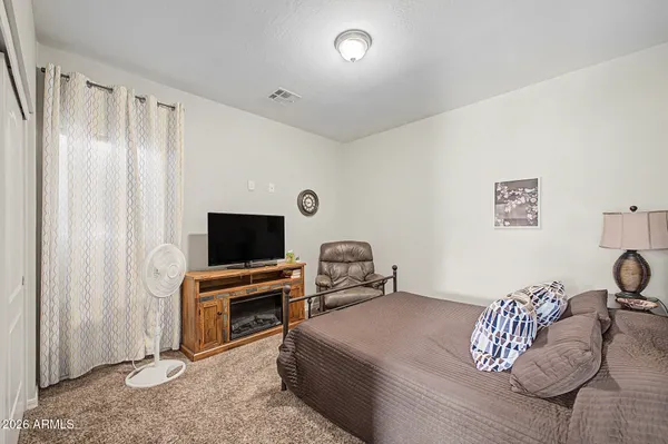 a bedroom with furniture and a flat screen tv