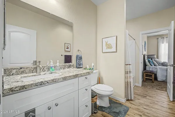 a bathroom with a granite countertop toilet sink and mirror