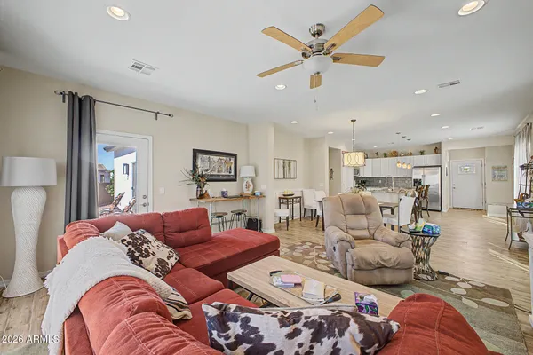 a living room with furniture kitchen view and a chandelier