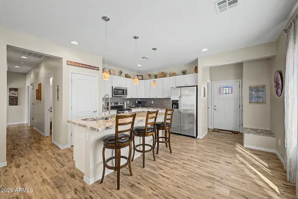 a kitchen with stainless steel appliances kitchen island granite countertop a refrigerator and a stove top oven