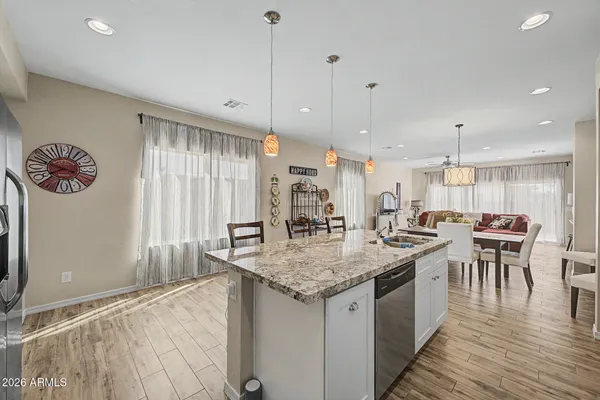 a kitchen with center island wooden floor center island and stainless steel appliances