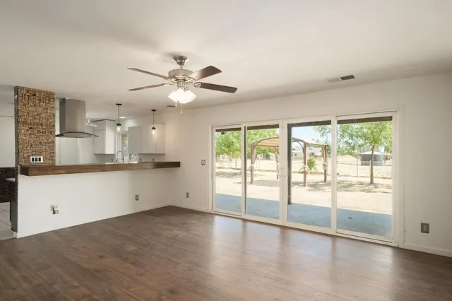 a view of an empty room with window and wooden floor