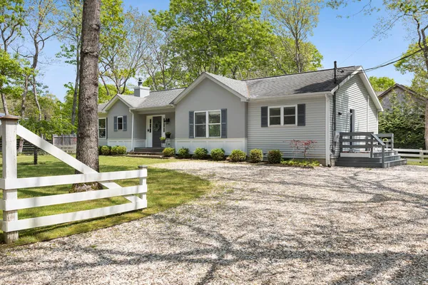 a view of a house with backyard and trees
