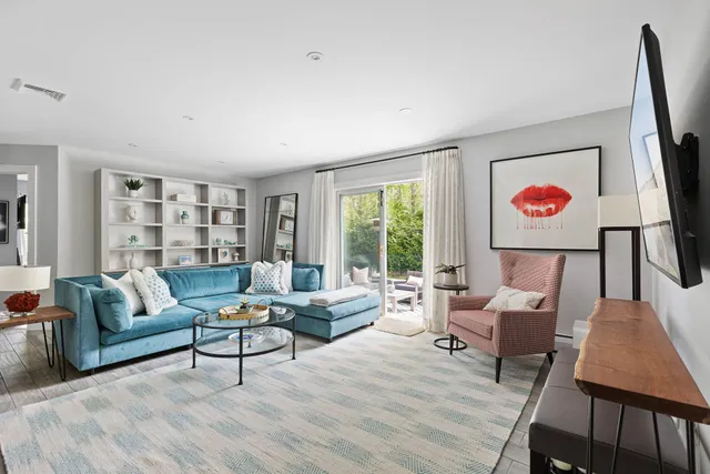 a living room with furniture and a painting on the wall