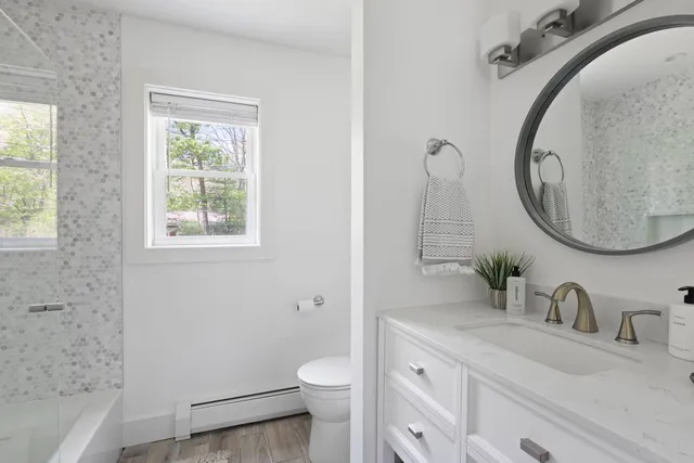a bathroom with a granite countertop toilet a sink and a mirror