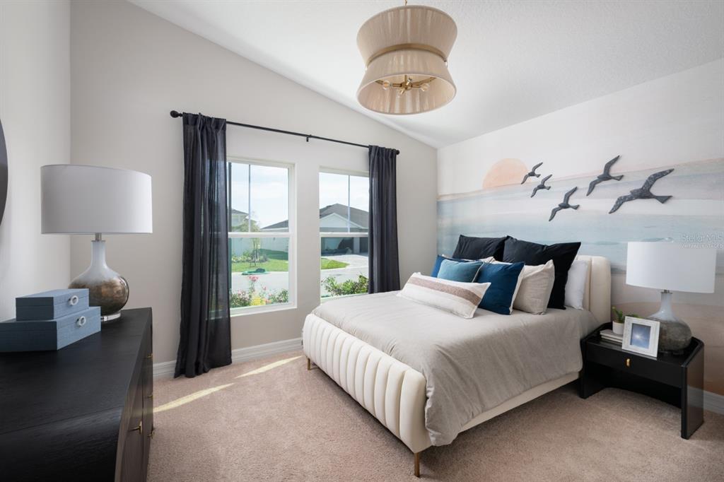 6144 Southwest 97th Street Ocala, FL 34476 - Photo 17 of 33 a bedroom with a bed and a chandelier