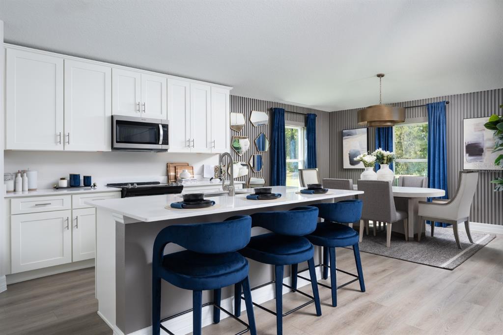 6144 Southwest 97th Street Ocala, FL 34476 - Photo 3 of 33 a kitchen with a dining table chairs and a sink