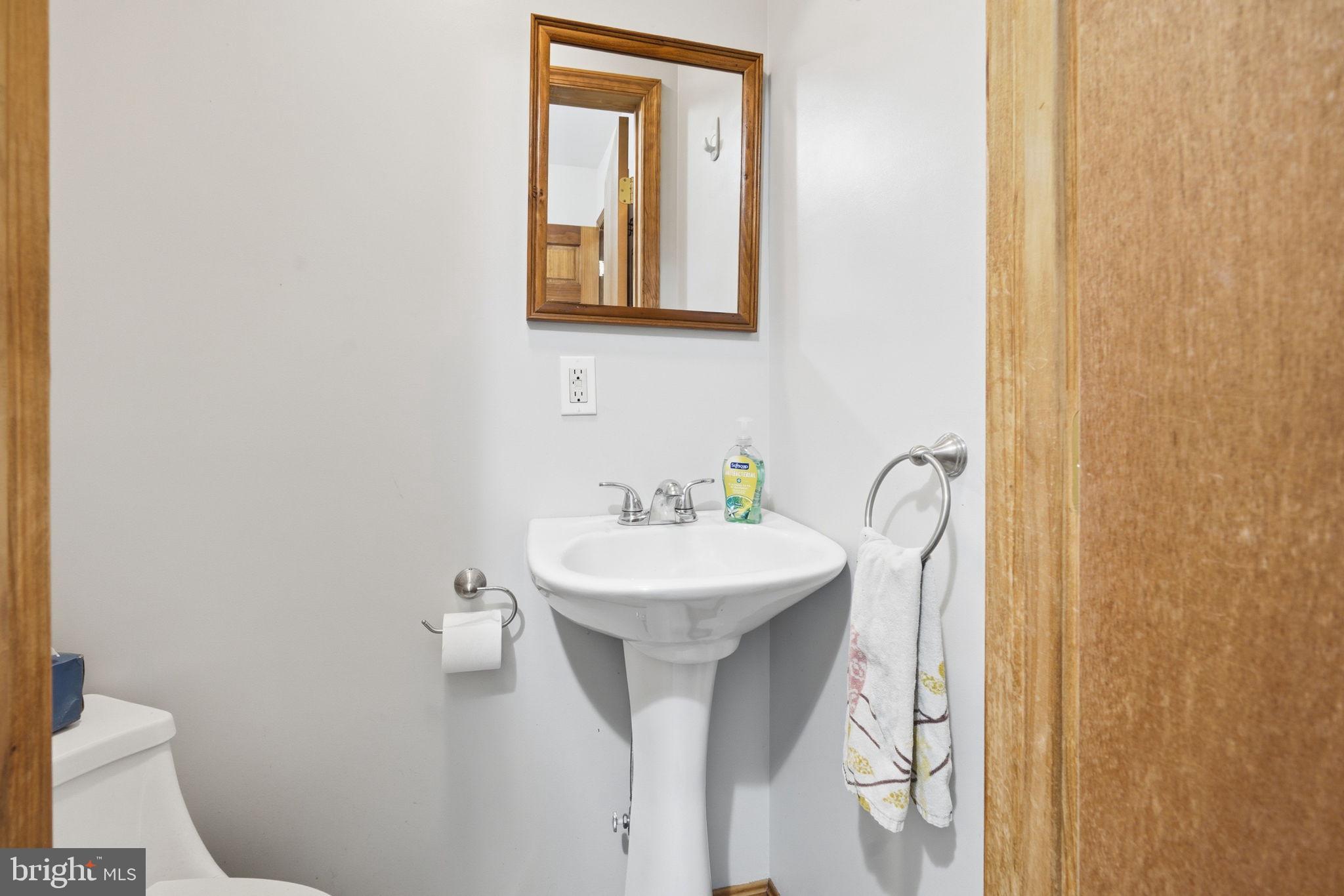 22300 Frazier Road Rock Hall, MD 21661 - Photo 14 of 38 a bathroom with a sink and mirror with toilet