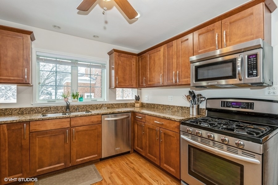 130 Northgate Road Riverside, IL 60546 - Photo 2 of 18 a kitchen with granite countertop wooden cabinets stainless steel appliances and a window