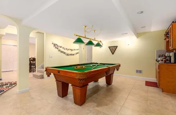 a room with pool table and potted plants