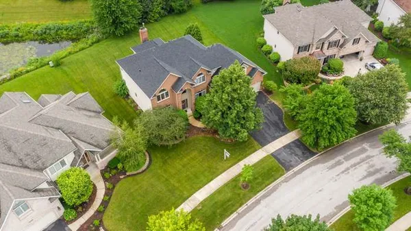 an aerial view of a house with a garden and lake view