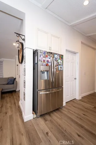 a kitchen with stainless steel appliances a refrigerator and a wooden floor