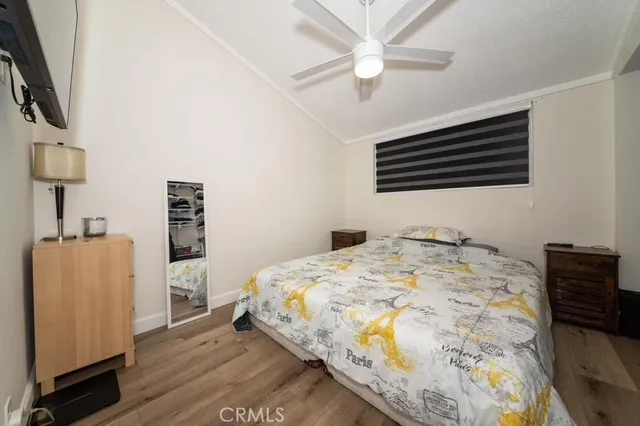 a bedroom with a bed and a flat tv screen on the dresser