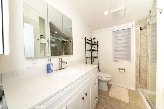 a bathroom with a sink a toilet and shower