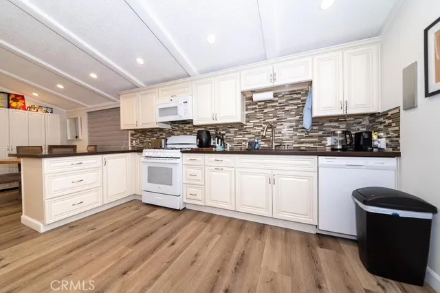 a kitchen with granite countertop white cabinets and white appliances