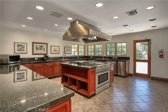 a large kitchen with stainless steel appliances granite countertop a stove and a sink