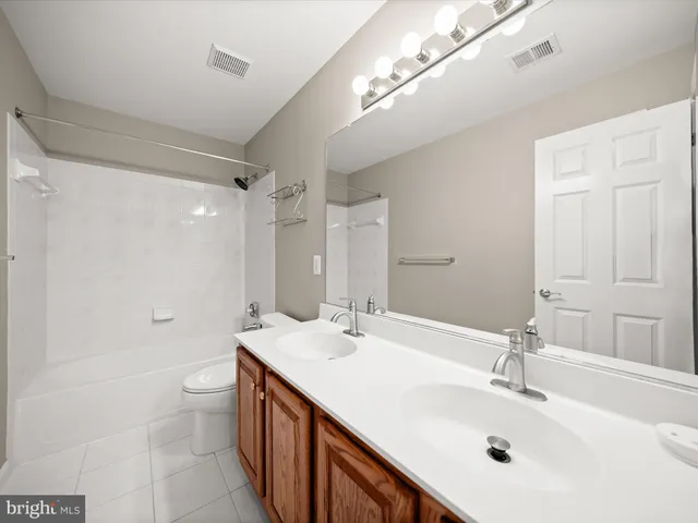 a bathroom with a double vanity sink mirror double and shower