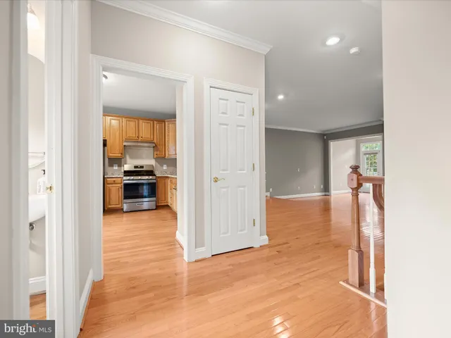 a view of a hallway with wooden floor and a living room