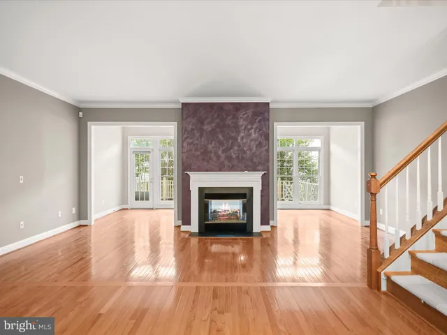 a living room with a fireplace and wooden floor