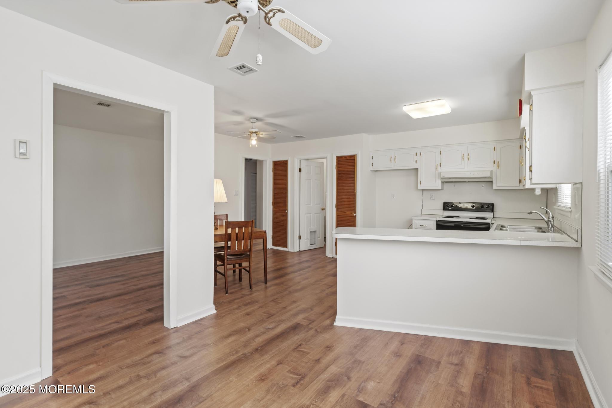 43 Patmore Road Brick, NJ 08724 - Photo 8 of 36 a kitchen with stainless steel appliances granite countertop a refrigerator a stove and white cabinets with wooden floor