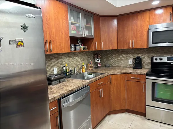 a kitchen with stainless steel appliances granite countertop a sink stove and microwave