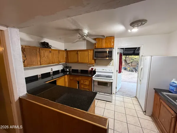 a kitchen with granite countertop a refrigerator stove and sink