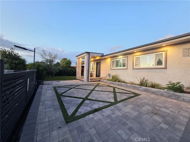 a view of a house with backyard and sitting area