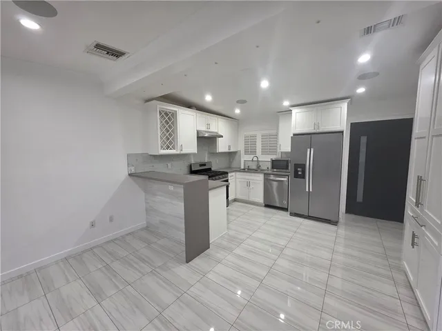a kitchen with stainless steel appliances granite countertop a refrigerator sink and cabinets