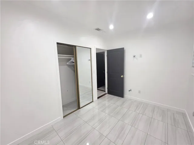 an empty room with closet and mirror