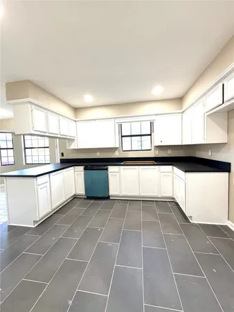 a view of a kitchen with windows and more cabinets