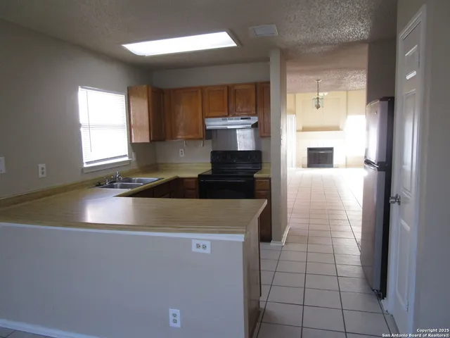 a view of a kitchen with a sink dishwasher and a refrigerator