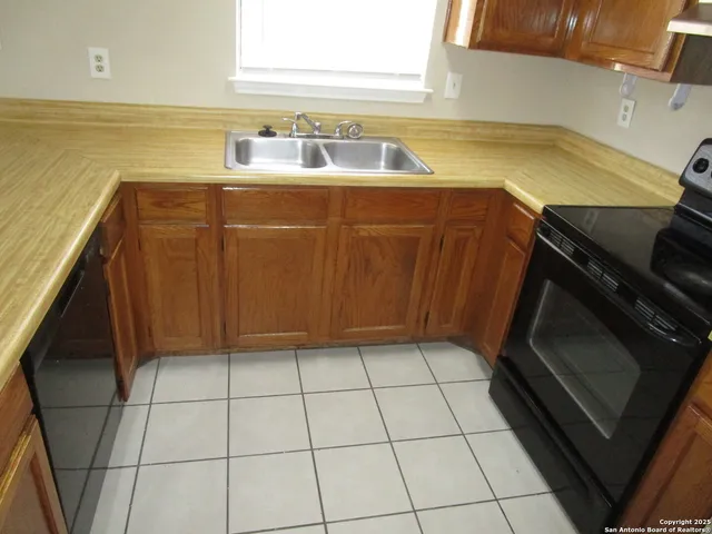 a kitchen with a sink a stove and cabinets