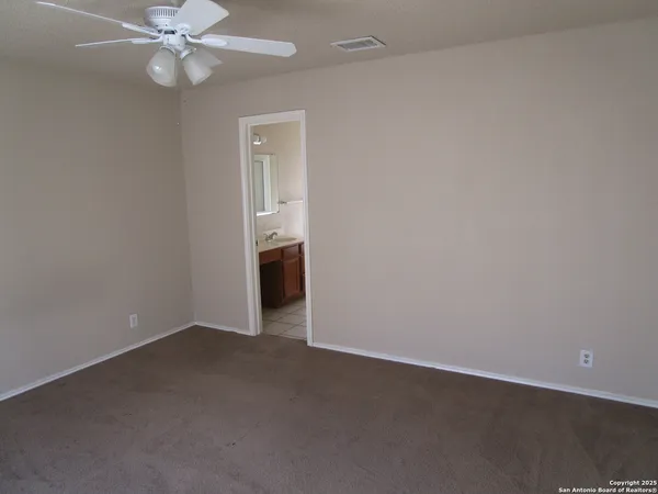 an empty room with closet and a chandelier fan