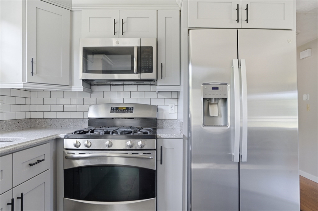 160 Navillus Road Tewksbury, MA 01876 - Photo 8 of 40 a kitchen with stainless steel appliances granite countertop a stove a refrigerator and a microwave