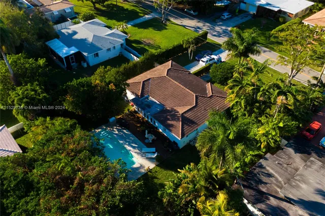 an aerial view of a house with a yard swimming pool and outdoor seating