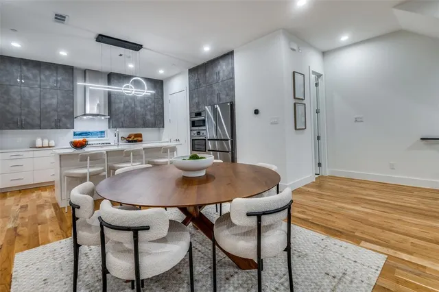 a kitchen with stainless steel appliances kitchen island a dining table and chairs