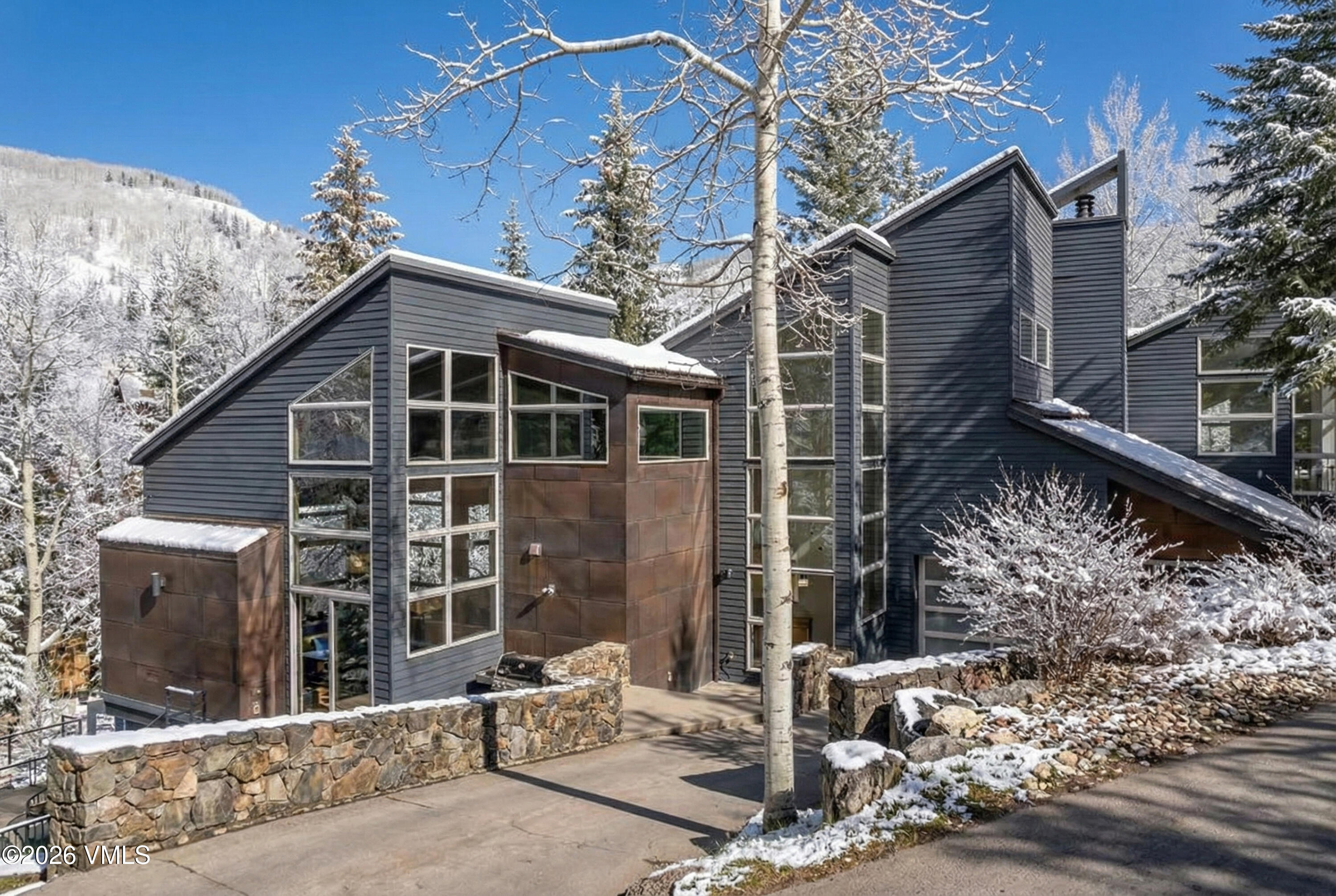a front view of a house with a tree