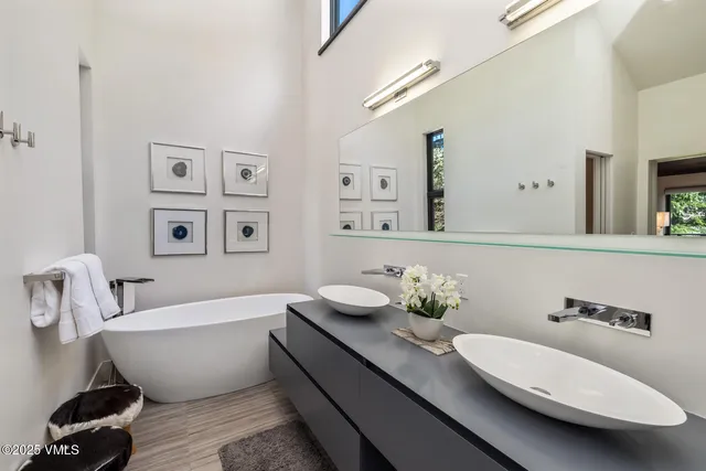 a bathroom with a white tub a sink and a mirror