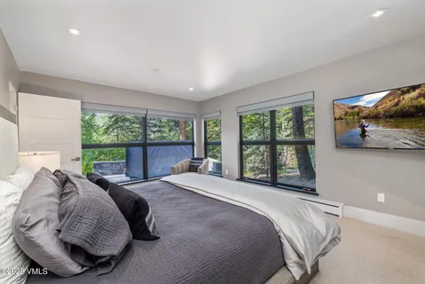 a bed sitting in a bedroom next to a large window