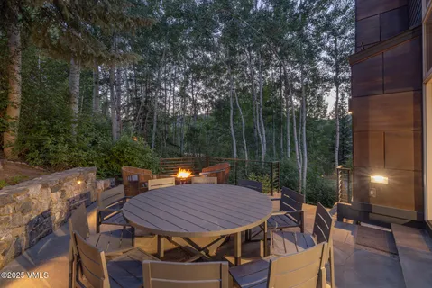 a view of a patio with a table and chairs a barbeque with wooden fence