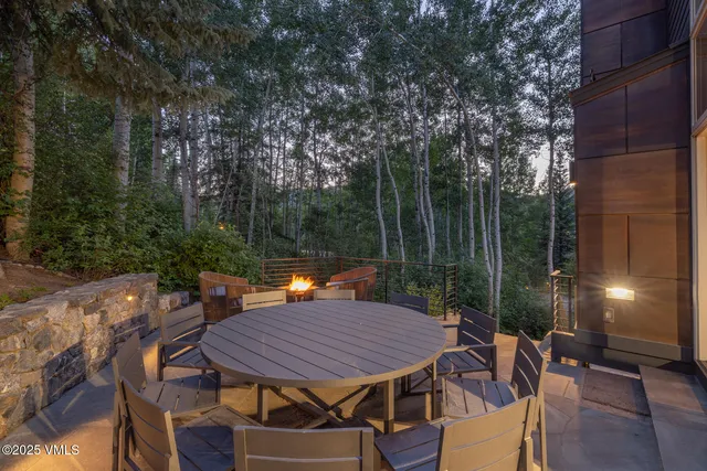 a view of a patio with a table and chairs a barbeque with wooden fence
